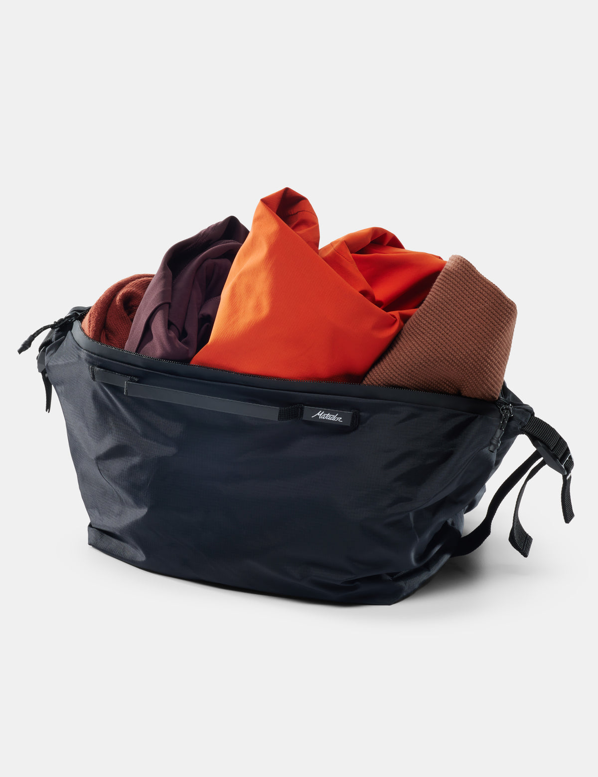 Black compression bag with clothes inside on a white background