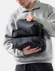 Person holding black gear cubes against a light gray background