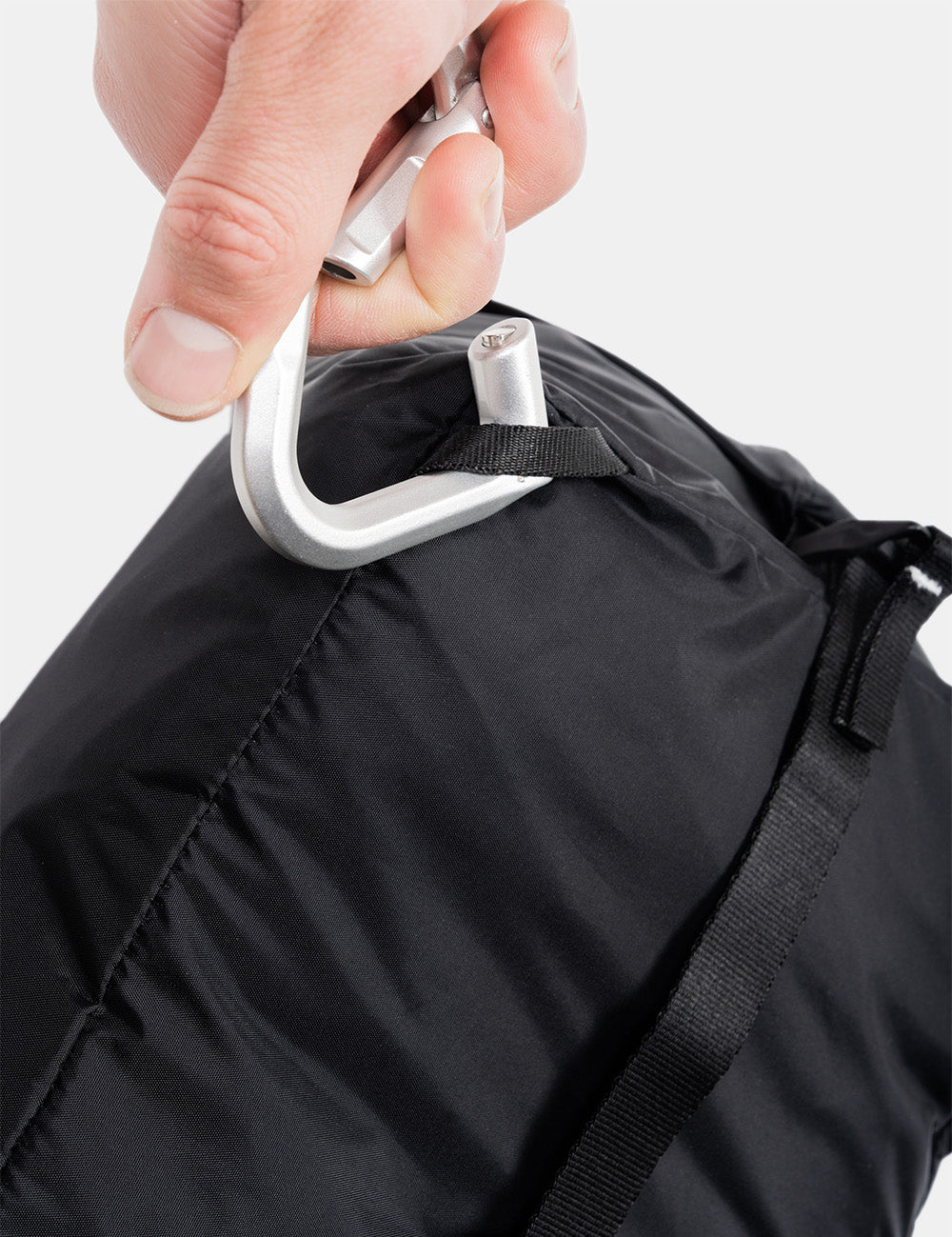 hand clipping carabiner onto gear cube