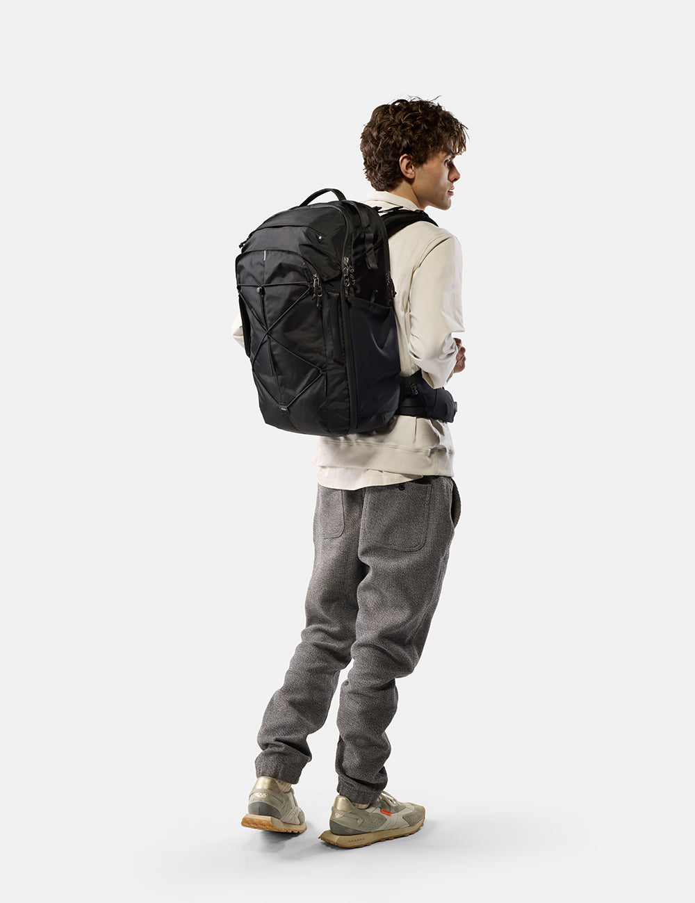 Person wearing a black backpack on a white background