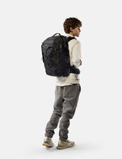 Person wearing a black backpack on a white background