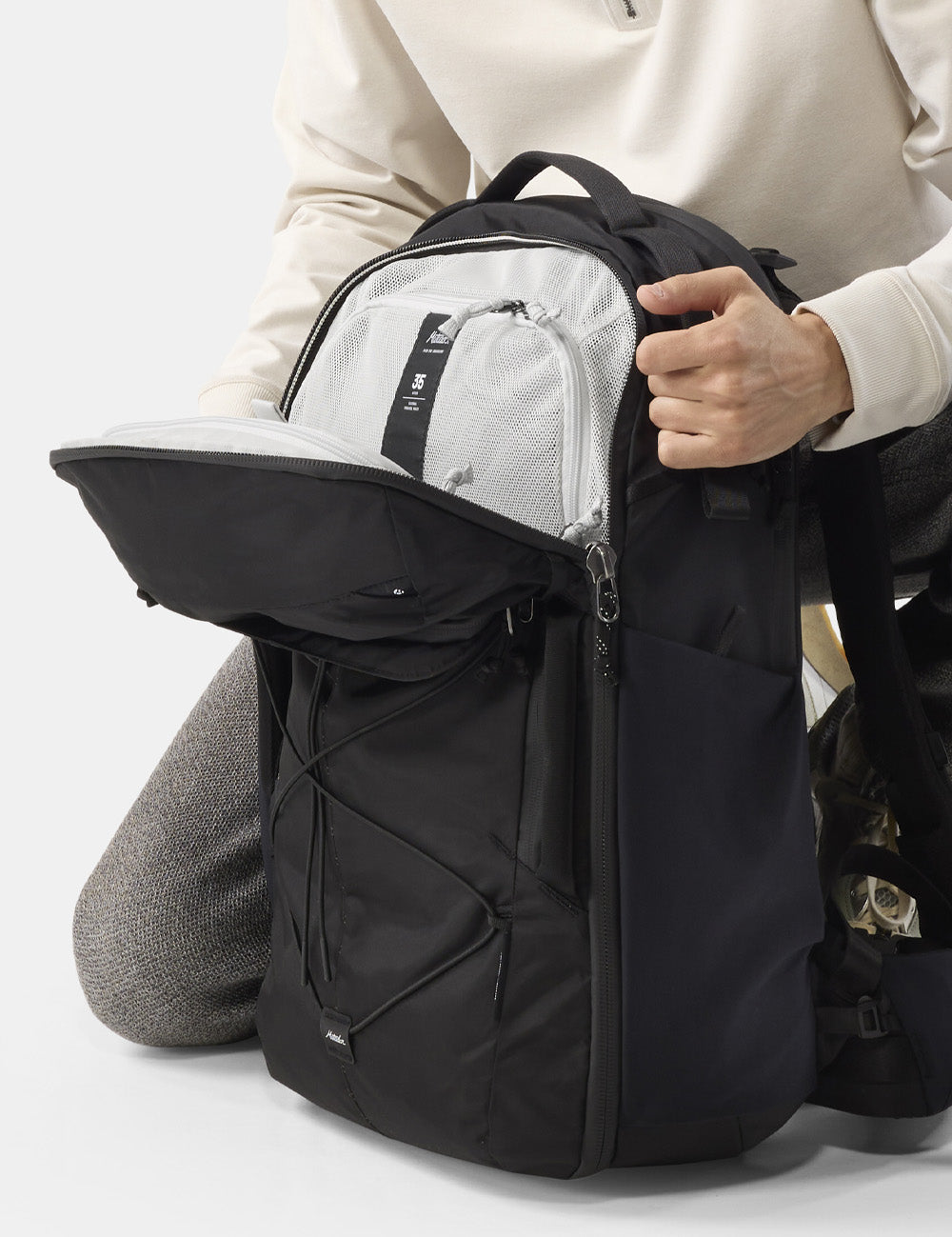 unzipping top of black backpack