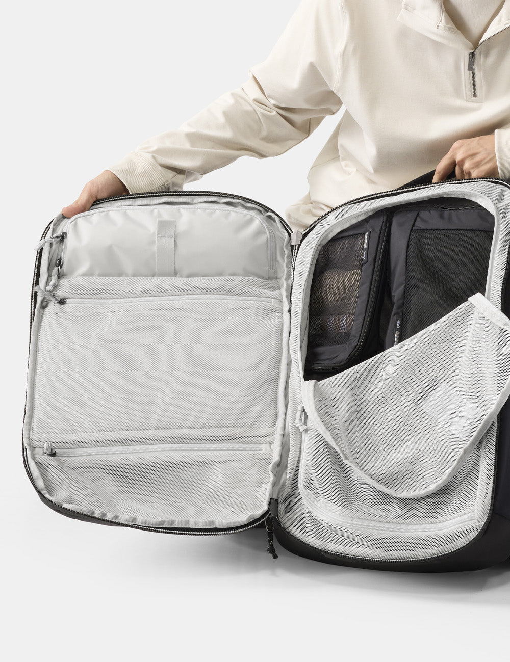 person holding open clamshell backpack