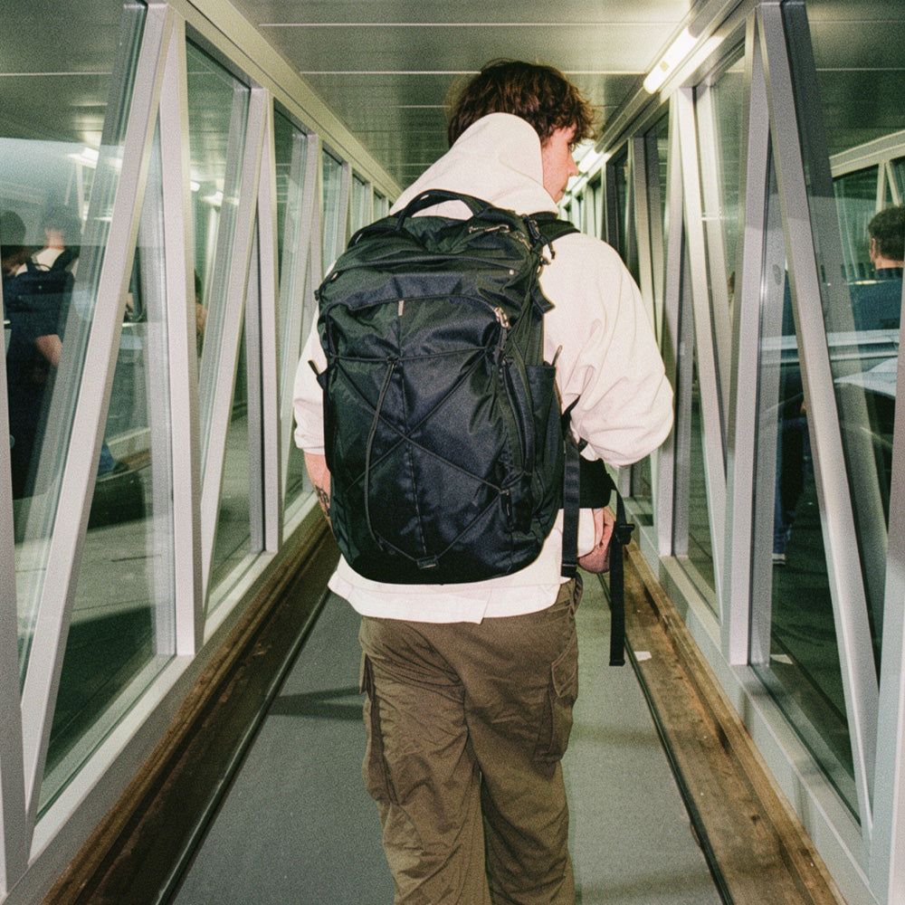 person walking on jetbridge wearing black backpack