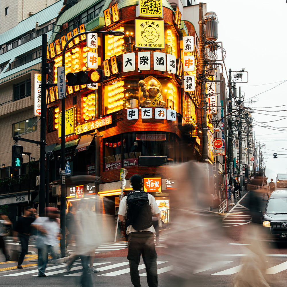 person in Japanese intersection with black backpack
