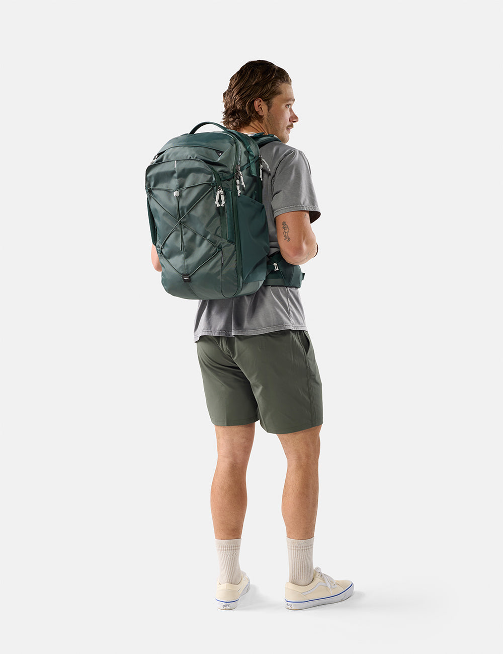 Person wearing a green backpack on a white background