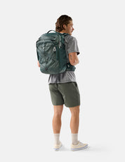 Person wearing a green backpack on a white background