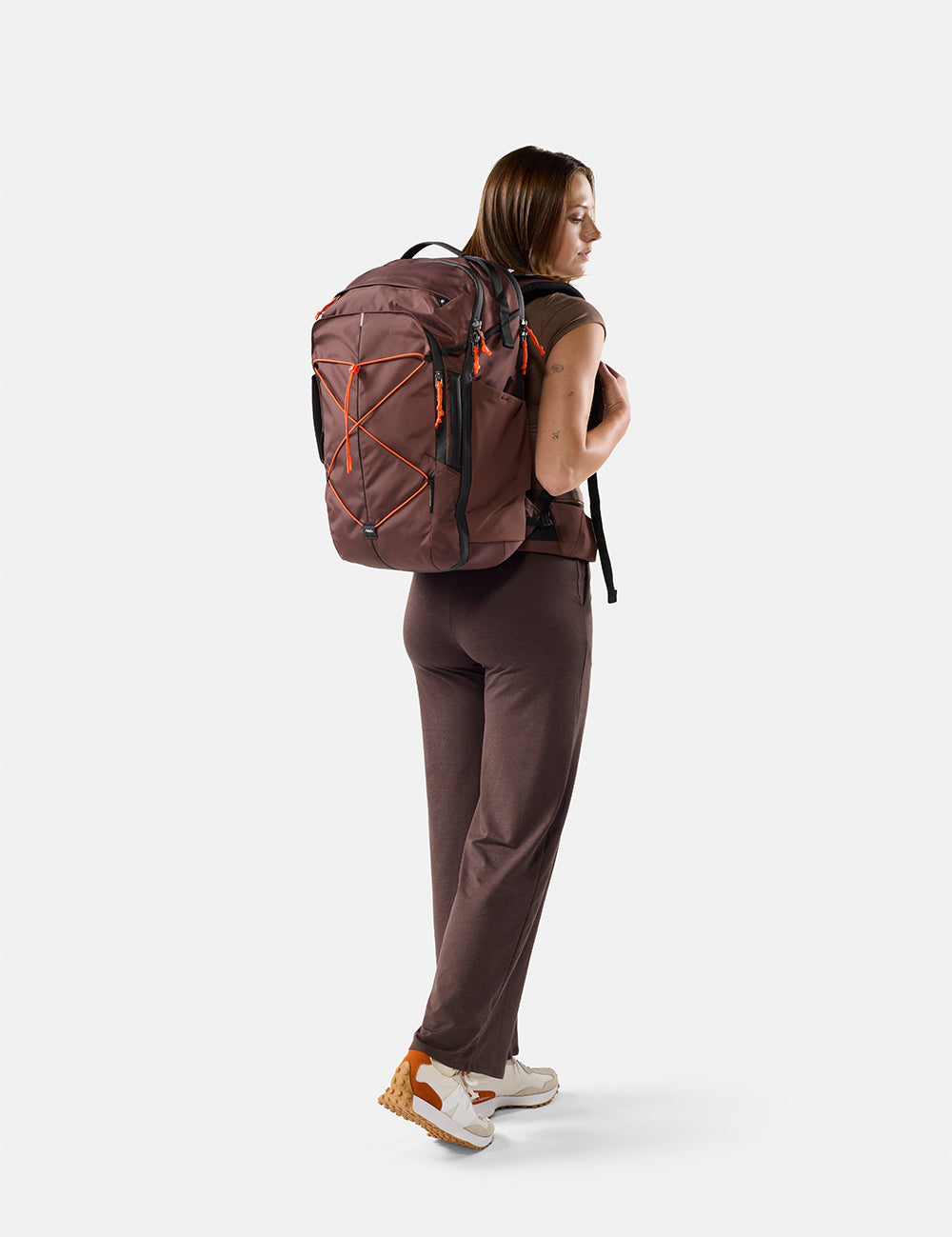 person wearing garnet bag with orange cord and pullers on white background