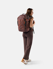 person wearing garnet bag with orange cord and pullers on white background