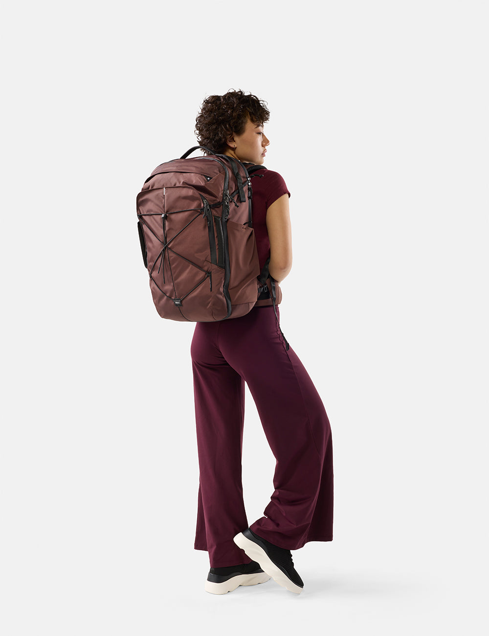 Person wearing a garnet backpack on a white background