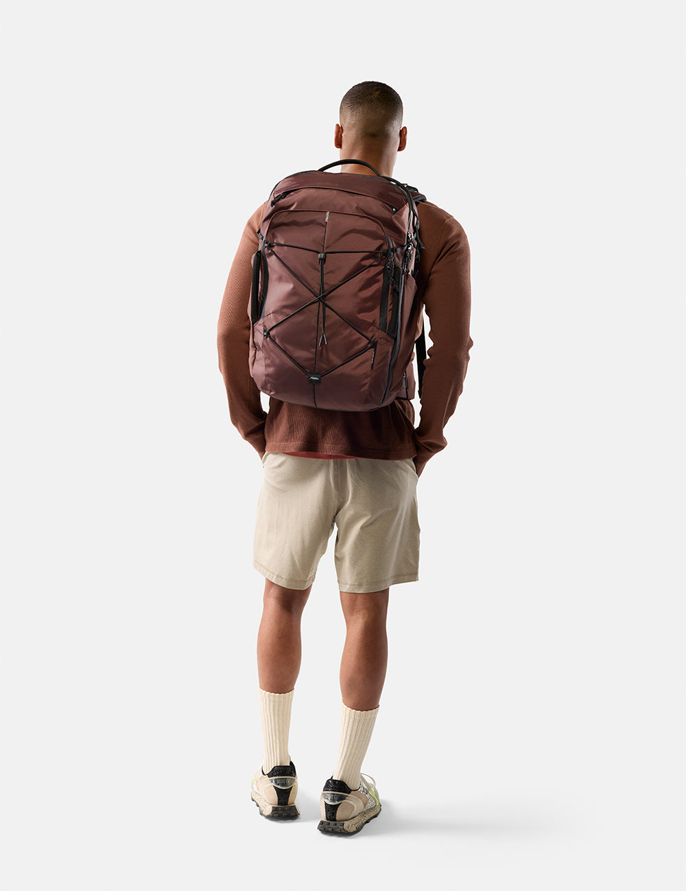 Person wearing a garnet backpack on a white background