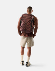 Person wearing a garnet backpack on a white background