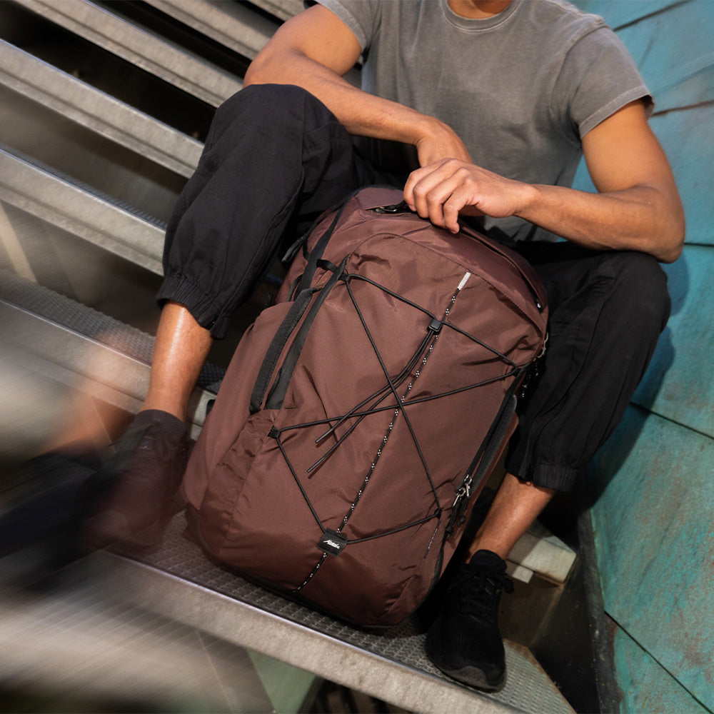 person sitting on stairs with garnet bag