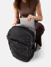 Person using a black backpack with a laptop on a white background