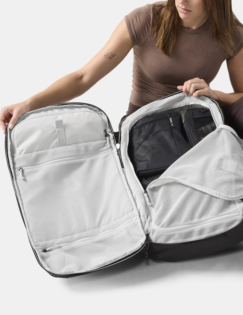person holding open clamshell backpack