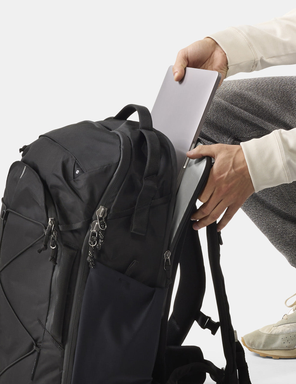 placing laptop into black backpack
