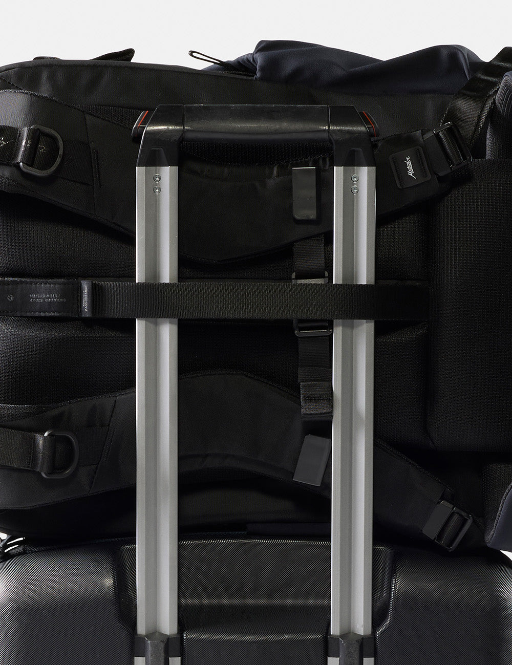 black backpack on rolling luggage handle