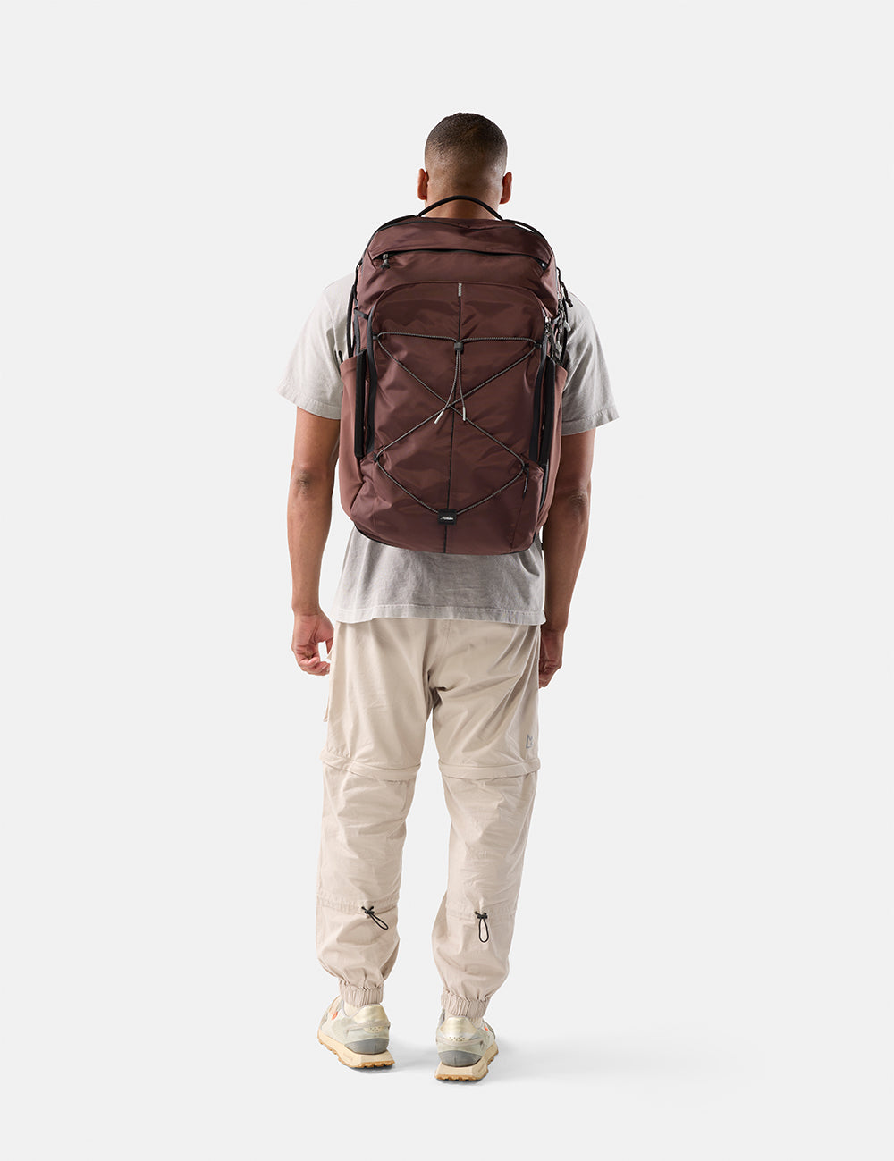 person wearing garnet bag with black cord and pullers on white background