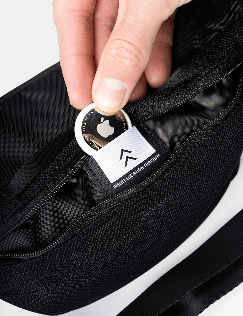 hand placing Apple AirTag into small pocket of sling