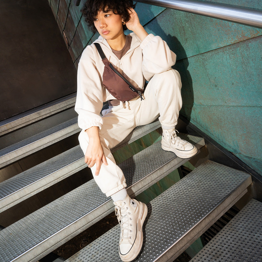 person sitting in stairwell with garnet sling