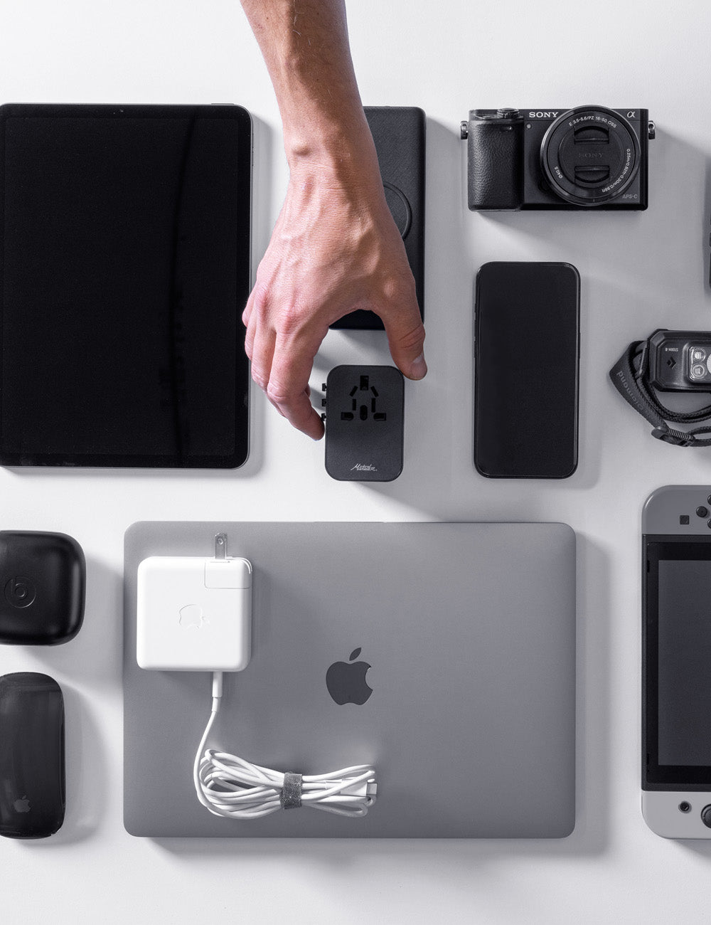 Travel Adapter held in hand with electronics
