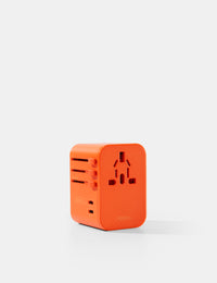 Orange travel adapter on a white background