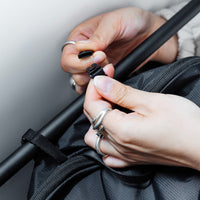ringed hands clipping laundry bag onto towel rod