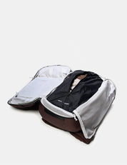Open backpack with dirty clothes on a light gray background