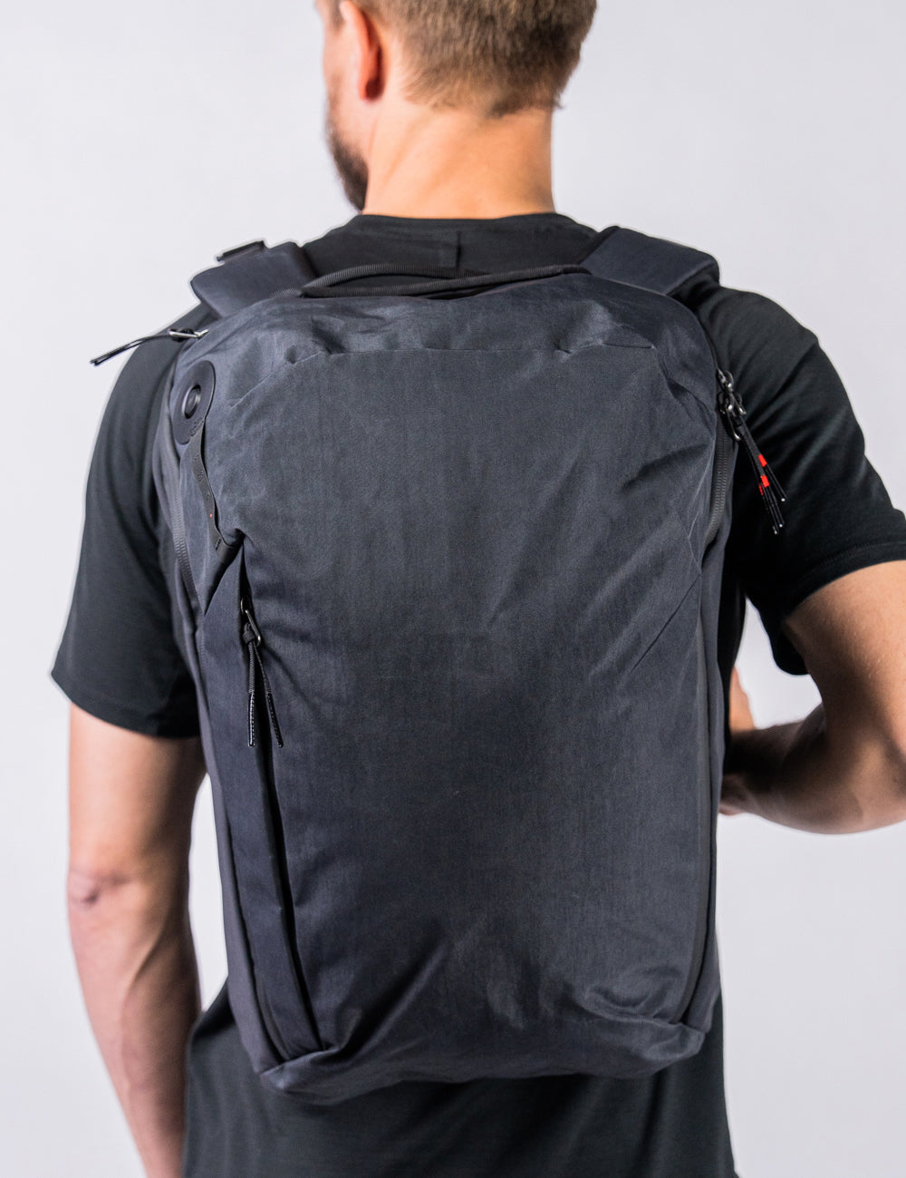man on white background wearing black backpack