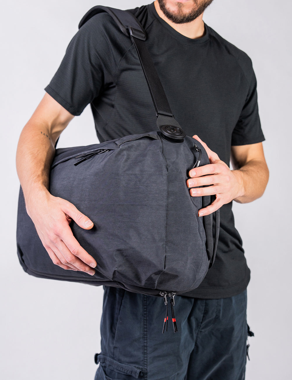 man holding a backpack like a duffel