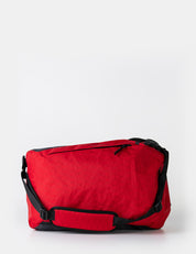 red backpack laying on side on white background