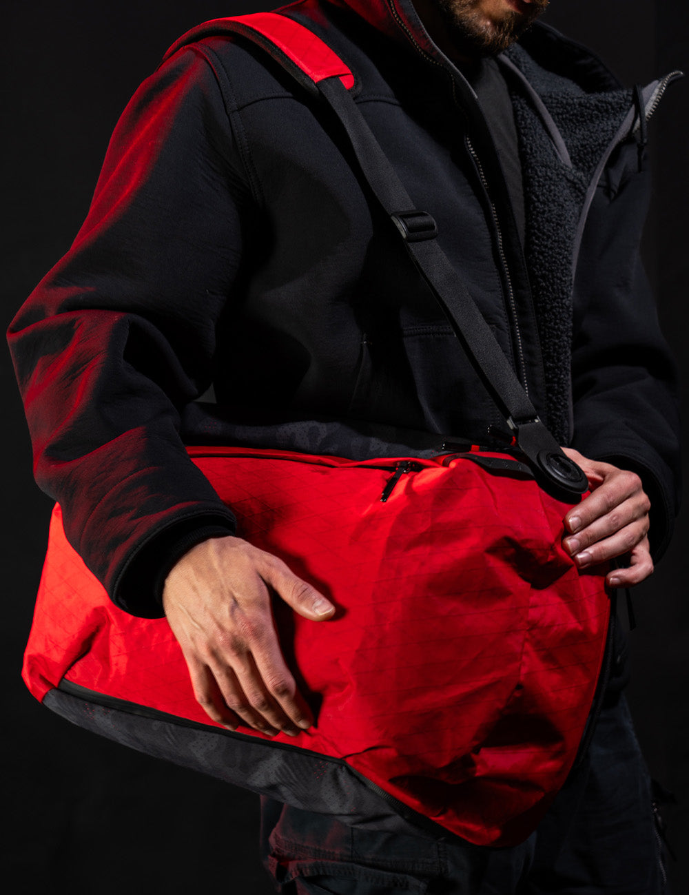 Person wearing a red bag on a dark background