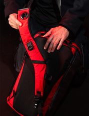 holding red backpack strap in dark setting