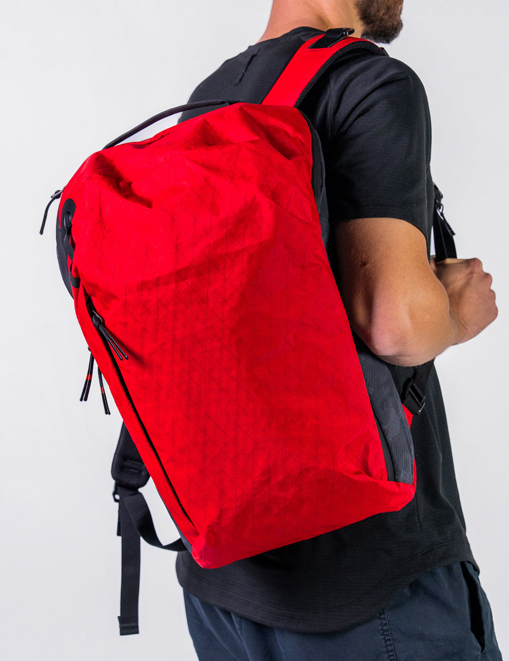 man wearing red backpack on white background