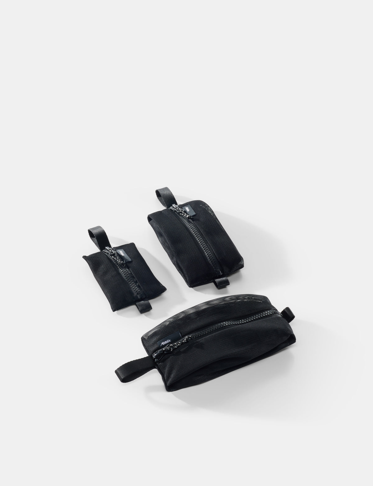 Three black pouches of varying sizes on a white background