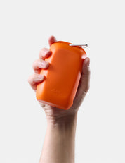 hand holding orange silicone case on white background