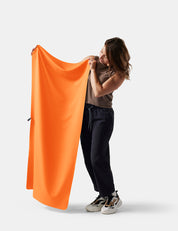 person holding orange towel on white background