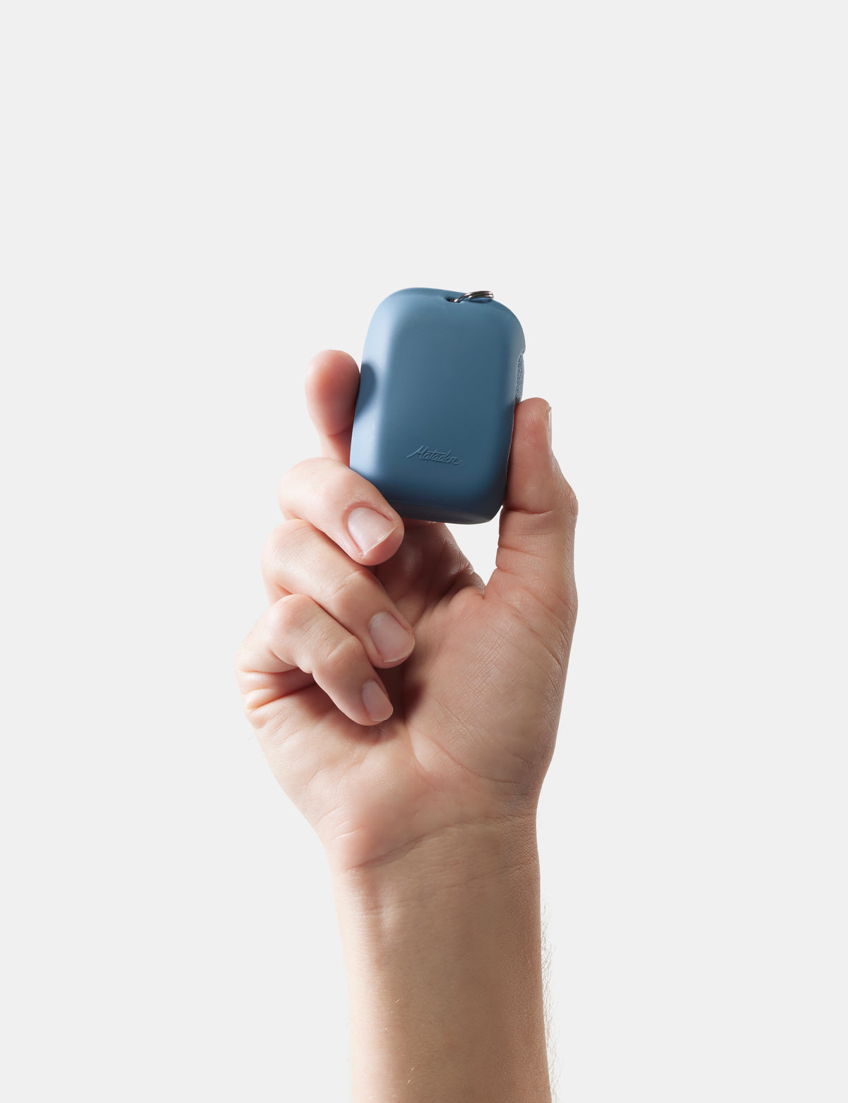 Hand holding a small blue towel case against a white background