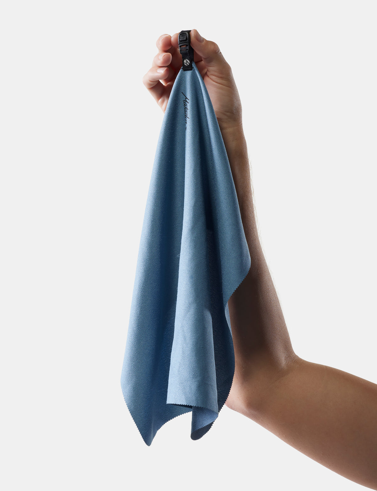 Hand holding a blue towel against a light gray background