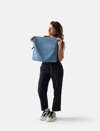 Woman holding a blue towel against a white background