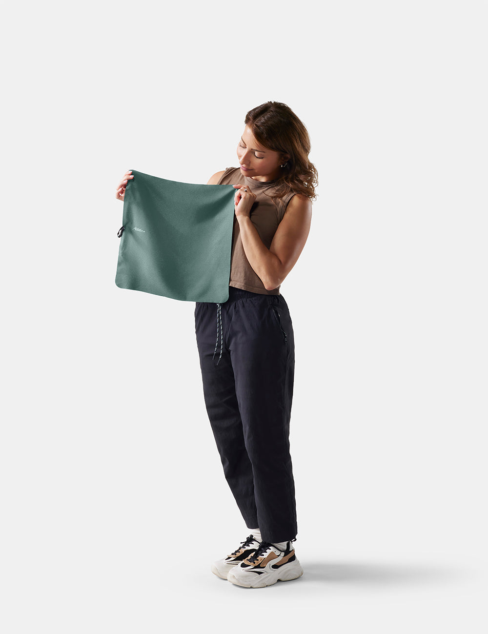 Woman holding a small juniper towel against a white background