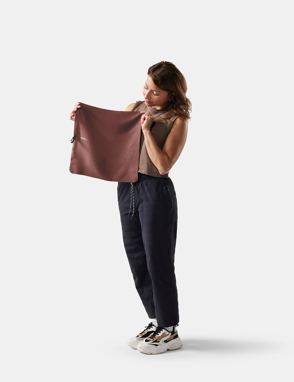 Woman holding a small garnet towel against a white background