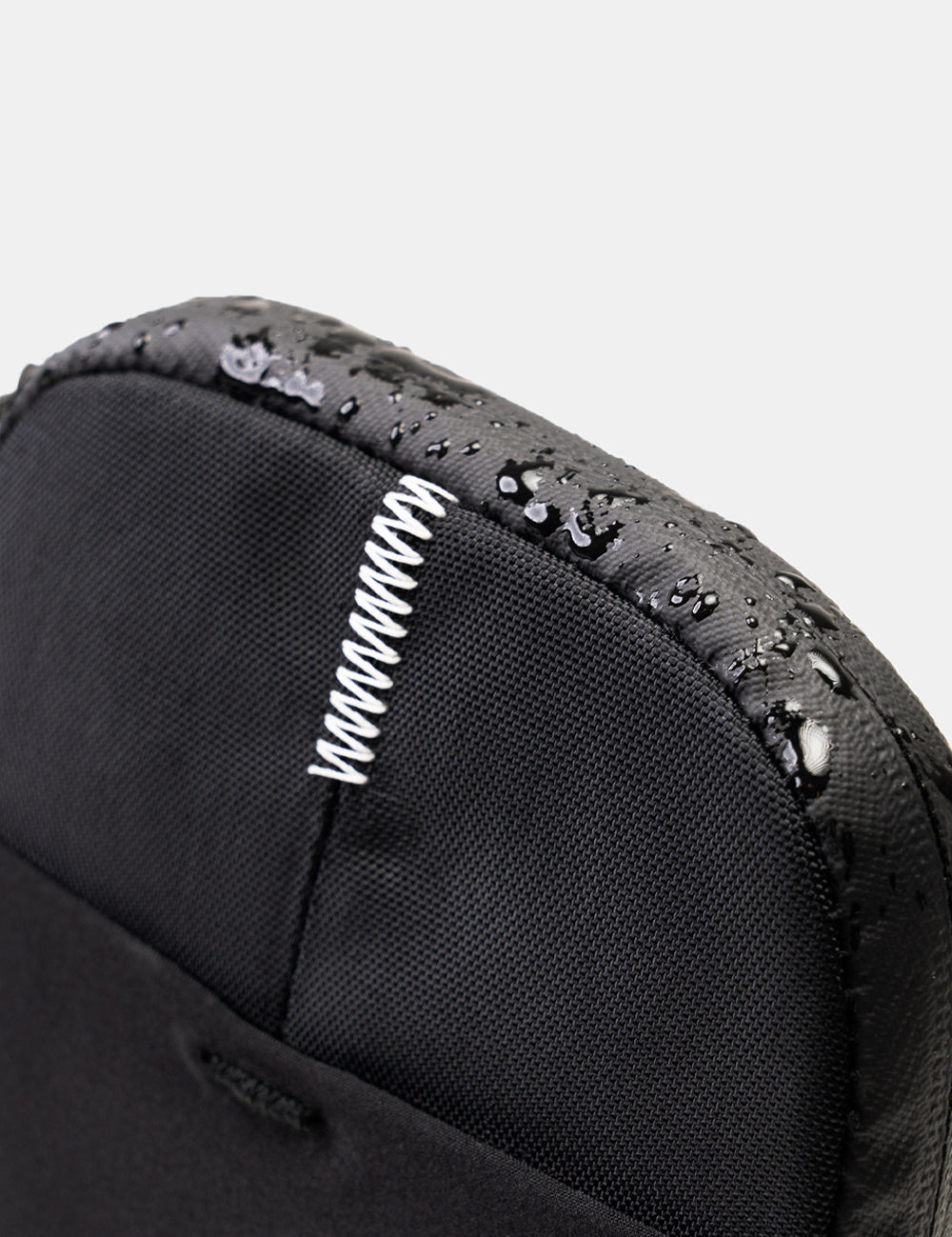 close up view of waterproof zipper and water drops beading off travel stash