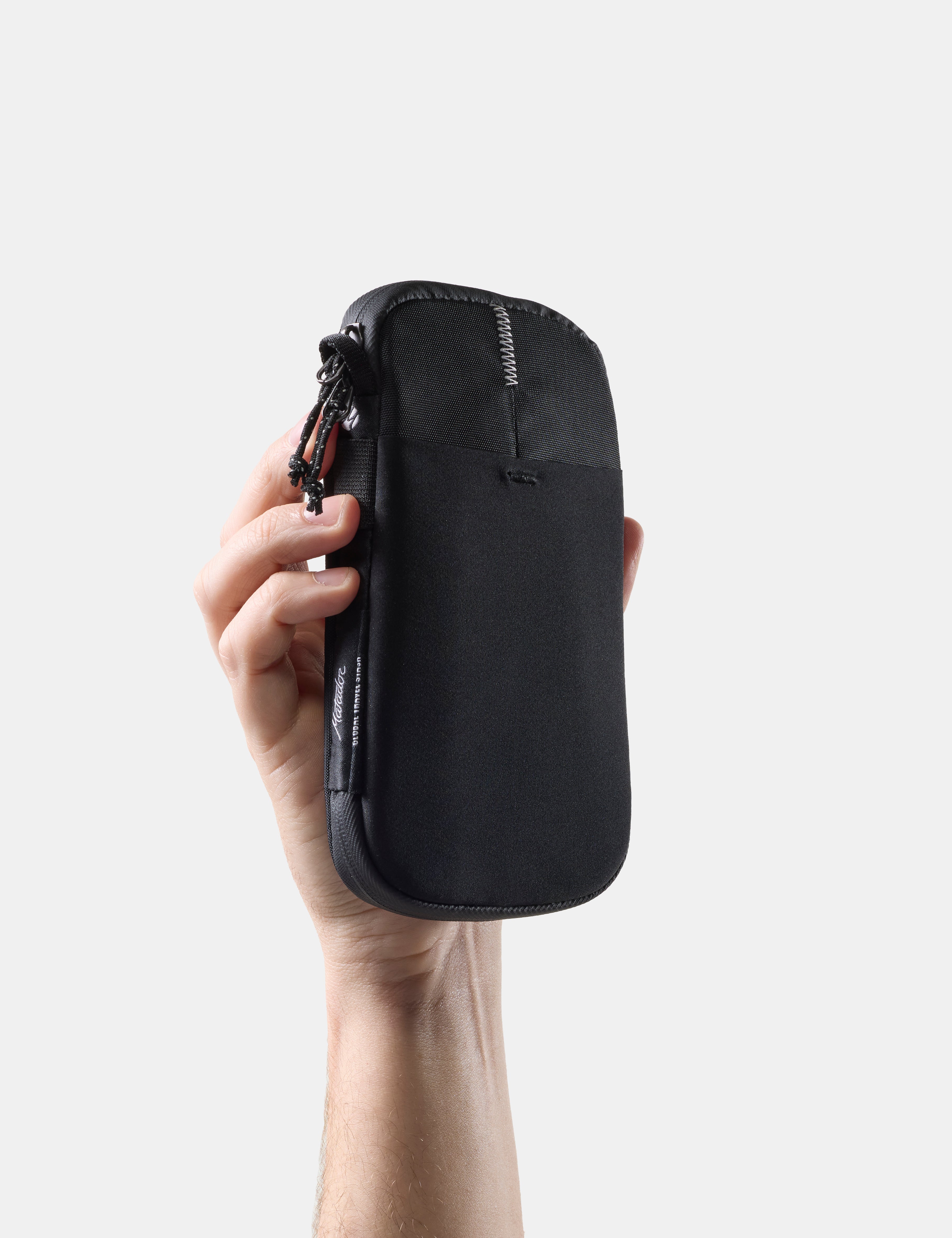 hand holding closed travel wallet on white background