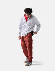 man on white background placing travel wallet in his pant pocket