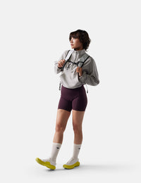 Person wearing a gray jacket, purple shorts, and yellow shoes on a white background