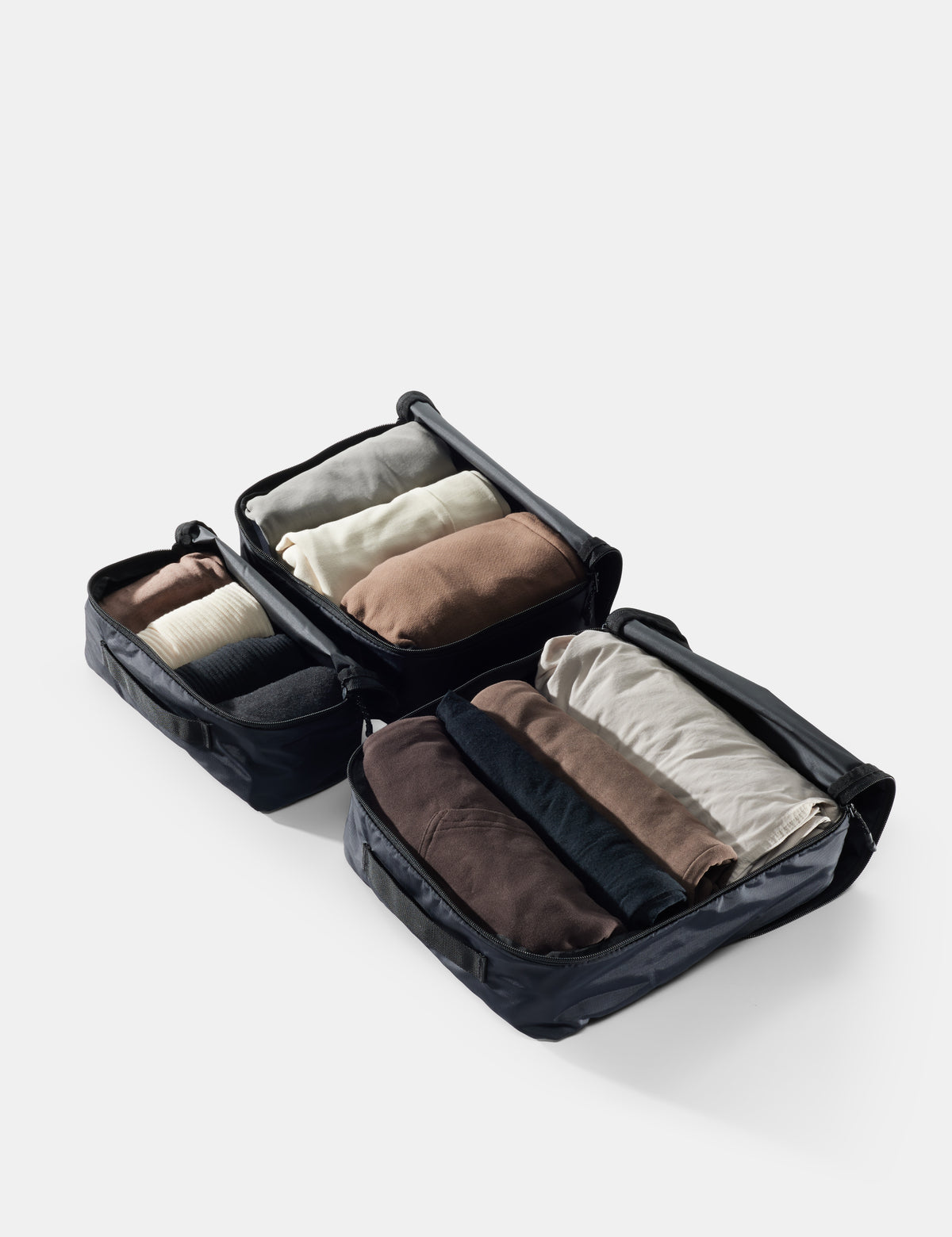 Black packing cube with folded clothes on a white background