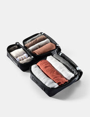 Compact travel organizer with neatly folded clothes on a light gray background