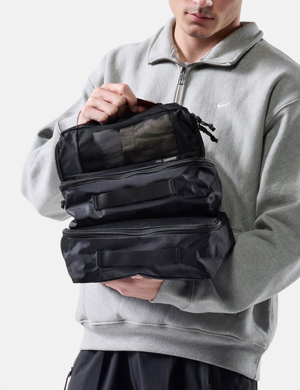 Person holding a black travel organizer with compartments.