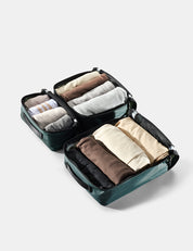 Compact travel organizer with folded clothes on a light gray background